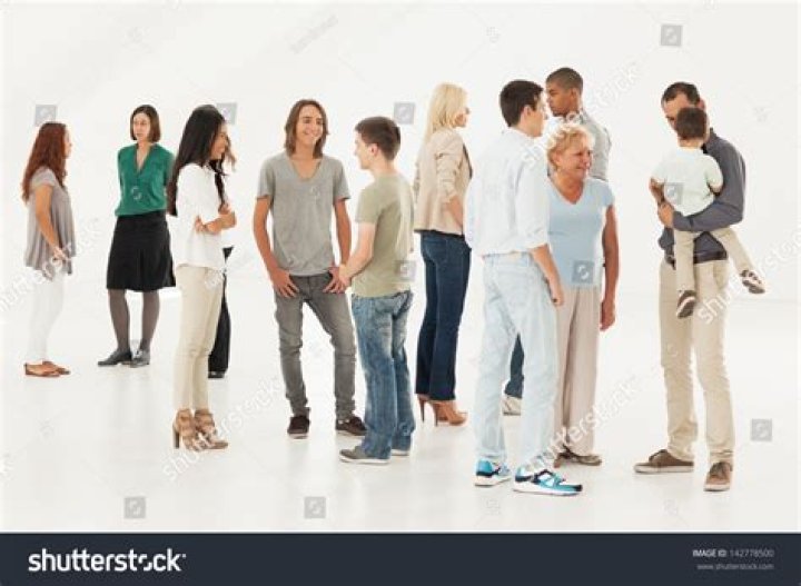 a group of people standing next to each other in front of a stadium