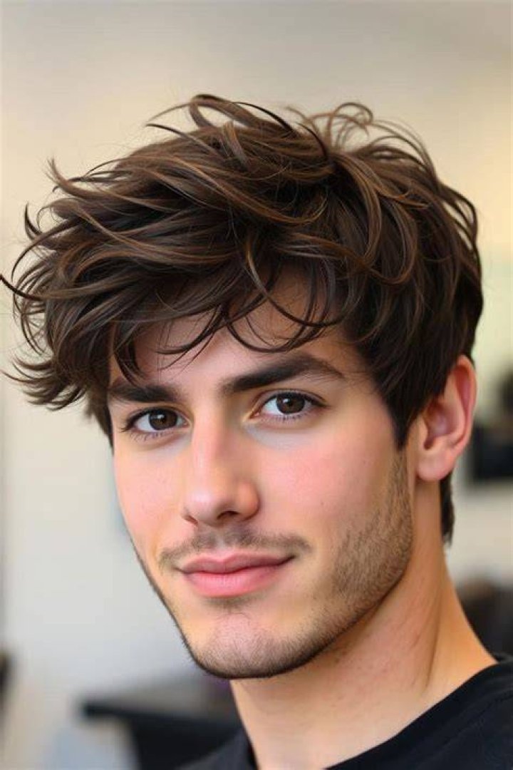 A man with dark hair wearing a black t shirt.
