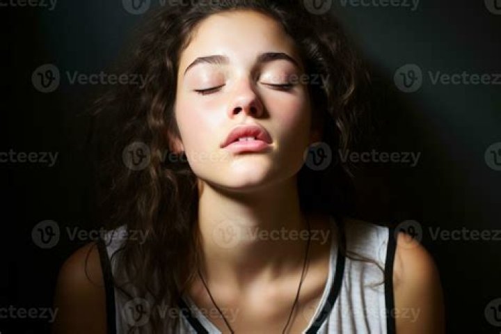 a woman with her eyes closed and a butterfly on top of her head that