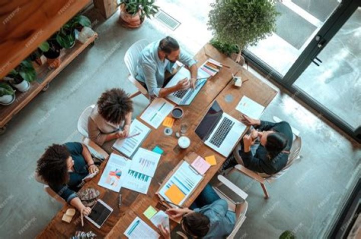 Group working around a table of laptops
