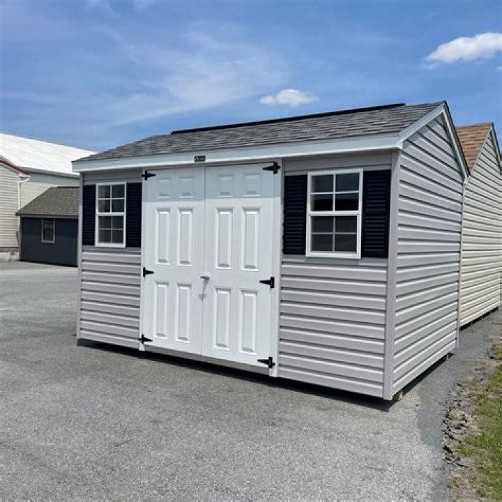 Outbuildings, a white van and construction waste can be seen