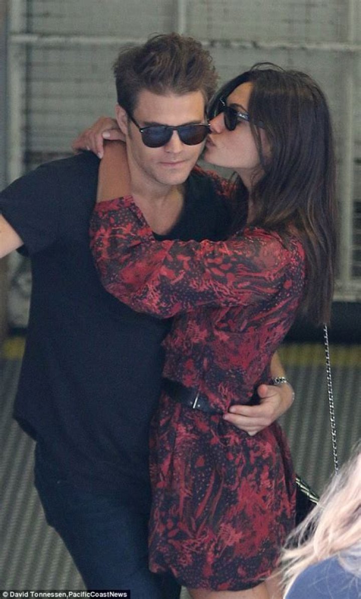Phoebe Tonkin plants a kiss on boyfriend Paul Wesley's cheek at Comic