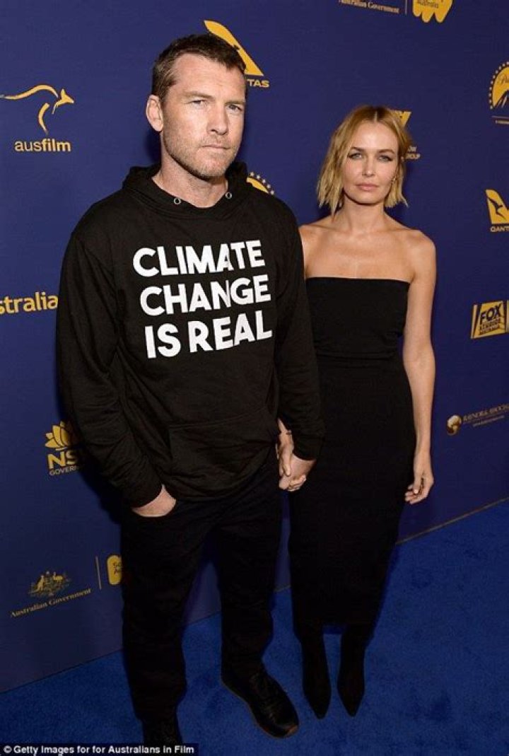 Sam Worthington wears a statement hoodie next to wife Lara at the