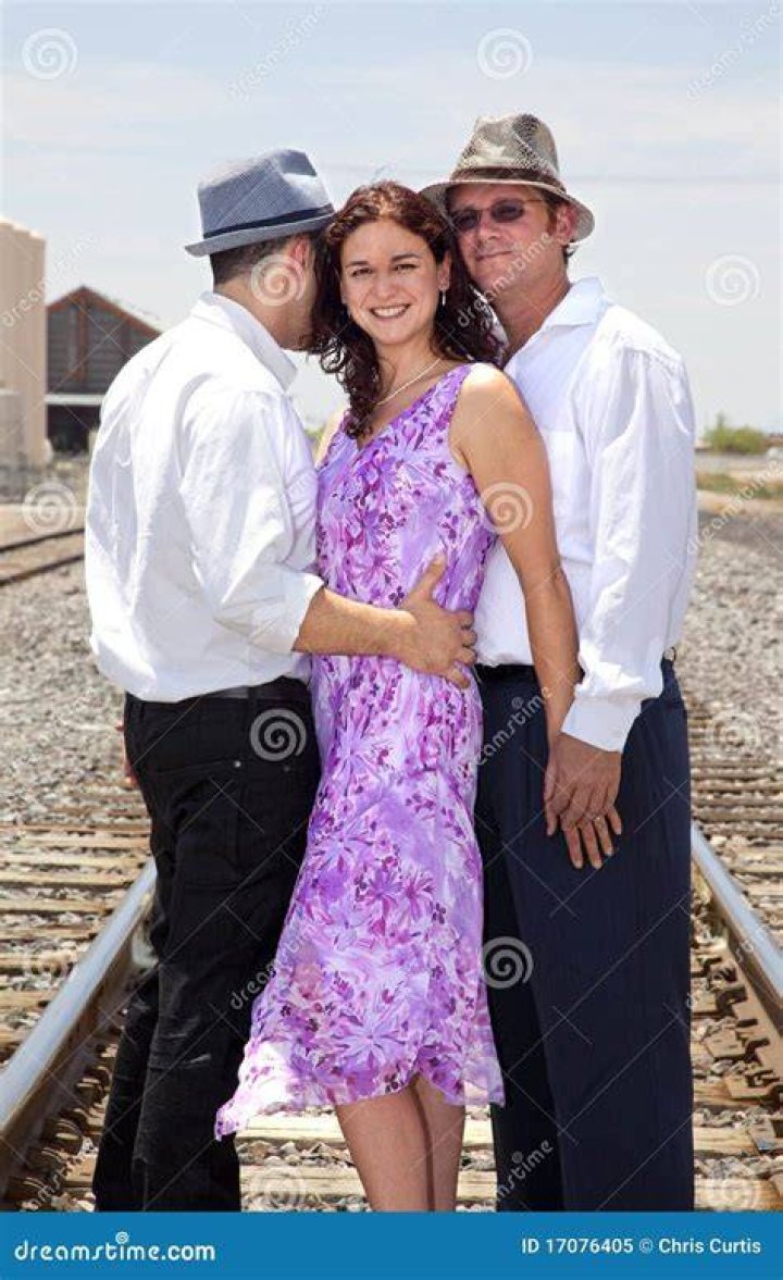 two men and a woman sitting next to each other in front of a window smiling