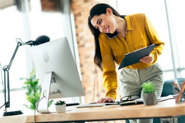 Woman in an office setting smiling at camera. 