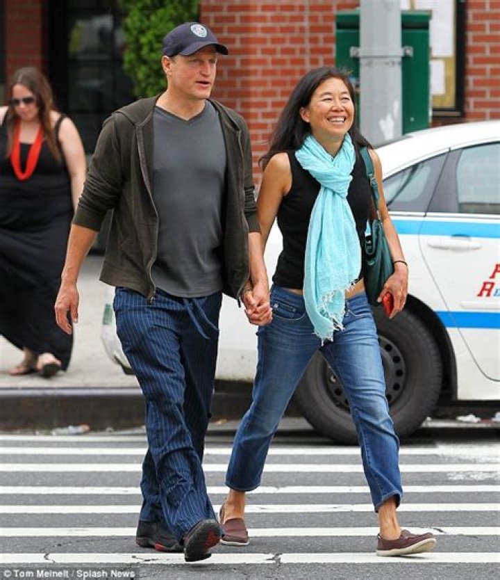 Woody Harrelson grins as he walks hand in hand with his wife Laura